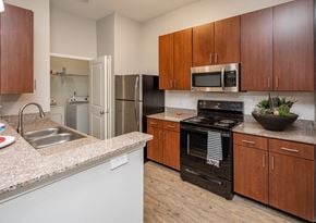 Murfreesboro apartment for rent - A kitchen with a black oven and wooden cabinets.