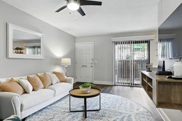 St. Louis apartment for rent - A living room with a white couch and a round table in the center.