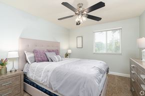 St. Louis apartment for rent - A bedroom with a bed, nightstands, and a ceiling fan.