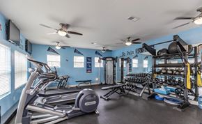 Murfreesboro apartment for rent - A gym with a variety of equipment including treadmills, weights, and a television.