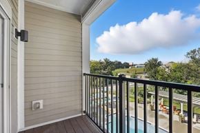 Weldon Springs apartment for rent - A balcony with a pool and trees in the distance.