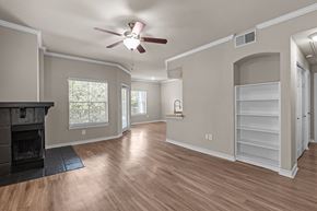 New Braunfels apartment for rent - A living room with a fireplace and a ceiling fan.