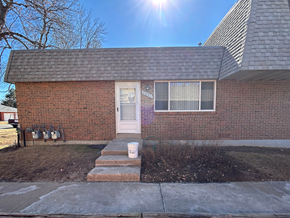 Fort Collins apartment for rent - A red brick house with a white door and a white bucket on the steps.