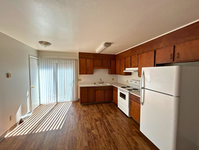 Fort Collins apartment for rent - A kitchen with white appliances and wooden cabinets.