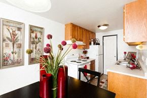 Fort Collins apartment for rent - A kitchen with a black table and red vases on it.