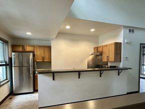 Fort Collins apartment for rent - A kitchen with a stainless steel refrigerator and wooden cabinets.