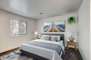 Fort Collins apartment for rent - A bedroom with a large bed and a painting on the wall.