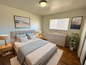 Fort Collins apartment for rent - A bedroom with a large bed and a nightstand with a lamp.