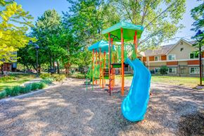 Fort Collins apartment for rent - A playground with a blue slide and a green roof.