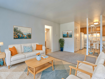 Fort Collins apartment for rent - A living room with a white couch, a coffee table, and a painting on the wall.