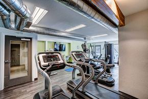 Fort Collins apartment for rent - A gym with treadmilers and a door.