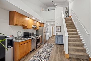 Hudsonville townhouse for rent - A kitchen with wooden cabinets and a staircase.