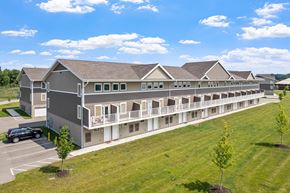 Hudsonville townhouse for rent - A large building with a parking lot in front of it.