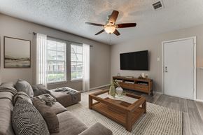 Corsicana apartment for rent - Living room with sectional sofa and entertainment center at Arbors Of Corsicana Apartments, Corsicana, 75110