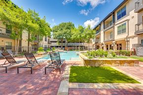Dallas apartment for rent - A pool surrounded by lawn chairs and trees.