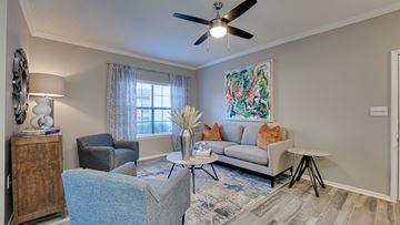 Fort Worth apartment for rent - an open living room with couches and chairs and a ceiling fan