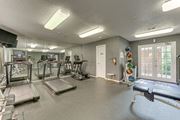 Bedford apartment for rent - A gym with treadmills, exercise equipment, and a mirrored wall at Copper Hill Apartments, Texas, 76021