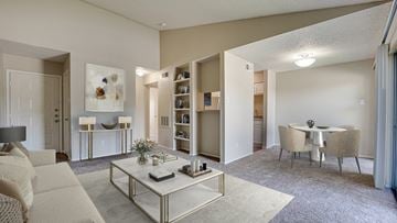 Bedford apartment for rent - A living room with a white sofa, a coffee table, and a dining table with chairs.