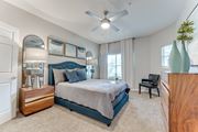 Lewisville apartment for rent - Bedroom with teal upholstered bed and wood furniture at Limestone Ranch Apartments, Texas, 75067