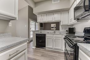 Dallas apartment for rent - A kitchen with a black stove top oven. at The Manhattan Apartments, Dallas, TX, 75252