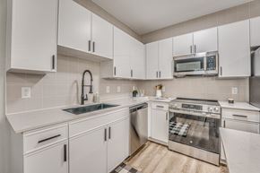 Dallas apartment for rent - Modern kitchen with white cabinets and stainless appliances at The Barton Apartments, Dallas
