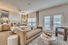 Dallas apartment for rent - A well-lit, modern bedroom with a large bed and a chair.