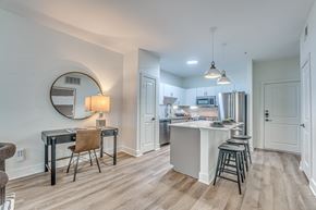 Dallas apartment for rent - A kitchen with a bar stool and a table with a chair.