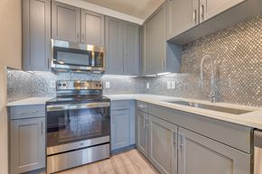 Grapevine apartment for rent - A modern kitchen with a stove top oven and microwave.