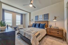 Grapevine apartment for rent - A bedroom with a bed, nightstand, and a plant.