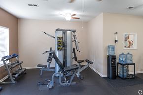 Simpsonville apartment for rent - A home gym with a weight machine, a bench, and a water cooler.