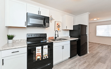 Travelers Rest apartment for rent - A kitchen with black appliances and white cabinets.