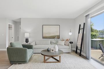 Lake Bluff apartment for rent - A living room with a green chair, a white couch, and a painting on the wall.