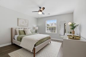 Lake Bluff apartment for rent - A bedroom with a bed, a fan, and a nightstand.