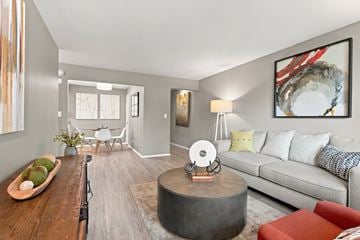 Carol Stream apartment for rent - A living room with a grey couch, a coffee table, and a large painting on the wall.
