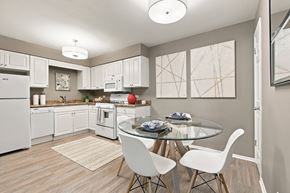Carol Stream apartment for rent - A modern kitchen with a glass table and white chairs.
