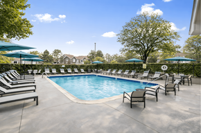 Buffalo Grove apartment for rent - A large outdoor swimming pool surrounded by lounge chairs and umbrellas.