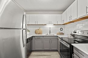 Oak Park apartment for rent - A modern kitchen with a stainless steel refrigerator and wooden cabinets.