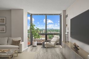 Oak Park apartment for rent - A living room with a large window overlooking a cityscape.
