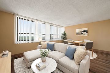 Chicago apartment for rent - A living room with a white couch, a coffee table, and a dining table with chairs.