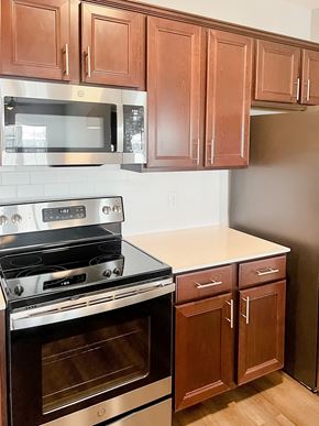 Bradenton apartment for rent - A kitchen with brown cabinets and a stainless steel oven.
