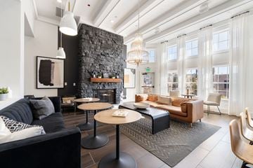 St. Charles apartment for rent - A modern living room with a black couch and a stone fireplace.