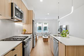 Spring townhouse for rent - A modern kitchen with wooden cabinets and stainless steel appliances.