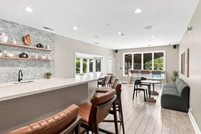 Naperville apartment for rent - A modern kitchen with brown leather chairs and a white countertop.