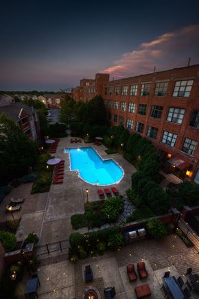 Villa Park townhouse for rent - A pool surrounded by a patio with chairs and umbrellas.