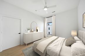 Houston apartment for rent - A bedroom with a large bed and a dresser with a mirror.