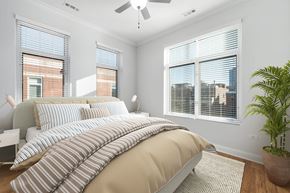 Chicago apartment for rent - A bedroom with a large bed and a ceiling fan.