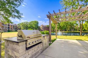Arlington Heights apartment for rent - A BBQ grill is on a stone base in a sunny park.