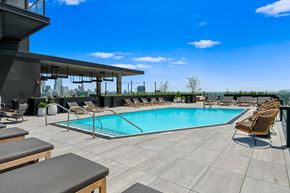 Chicago apartment for rent - A pool area with lounge chairs and a view of the city.