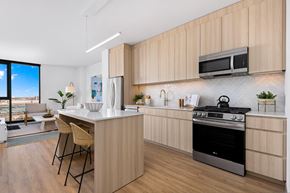 Chicago apartment for rent - A modern kitchen with wooden cabinets and a black stove top oven.