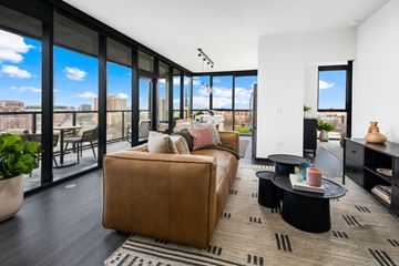 Chicago apartment for rent - A living room with a brown couch and a view of the city.